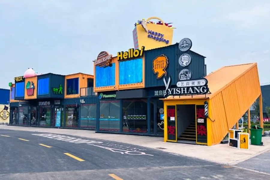 Row of colourful shipping container shops in a commercial plaza