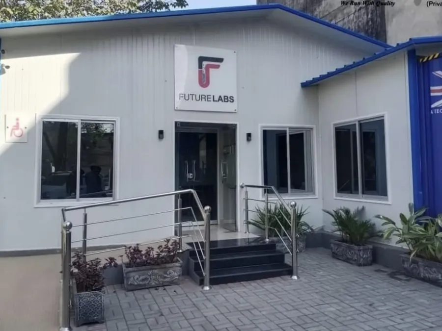 White prefabricated office building with glass entrance, steel handrails and potted plants